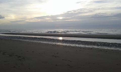 strand De Panne en ondergaande zon bij zee La Tourelle De Panne